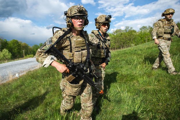 Army soldiers work together as they move to an objective while participating in a tactical event.