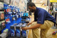 AAFES employee Travis Daniels organizes video game consoles in the electronics department at The Exchange on Grand Forks Air Force Base, North Dakota. (U.S. Air Force/Luis Loza Gutierrez)
