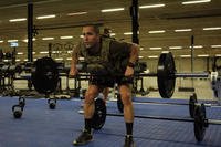 Commander performs barbell rows.