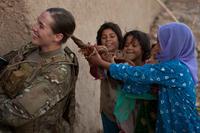 U.S. Army soldier lets a group of Afghan girls play with her ponytail.