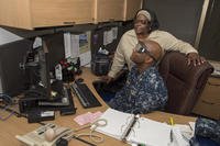 Cmdr. Edward K. Westbrook II has an office teammate read him an email while he wears goggles to simulate blindness during National Disability Employment Awareness Month.