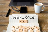 an arrangement of desktop items featuring the words capital gains tax