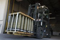 Airmen use a forklift to move 155 mm shells bound for Ukraine