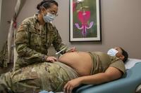 Army obstetrician measures the growth of a patient's pregnancy