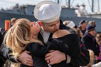 Navy sailor embraces his family following USS Normandy's return