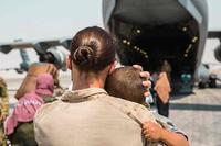 U.S. Marine carries a child to a plane at Al Udeid Air Base