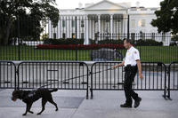 In this Sept. 22, 2014, file photo, a member of the Secret Service Uniformed Division with a K-9 walks along the perimeter fence along Pennsylvania Avenue outside the White House in Washington. (AP Photo/Carolyn Kaster, File)