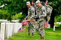 3d U.S. Infantry Regiment soldiers place American flags in front of graves at Arlington National Cemetery. (Photo Credit: 3d U.S. Infantry Regiment)
